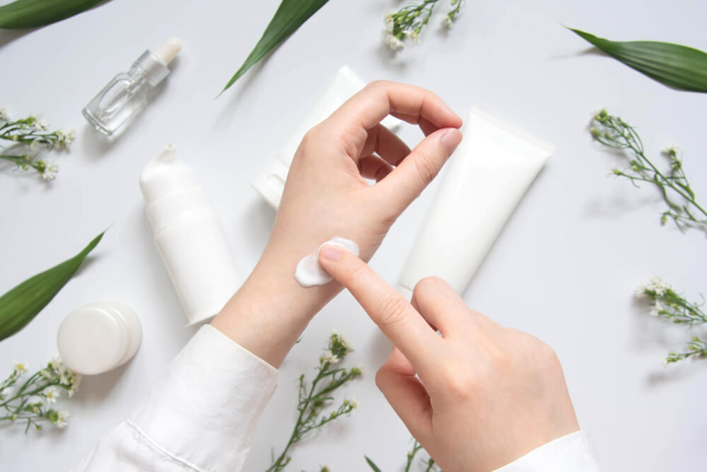 Woman applying skin cream to hand