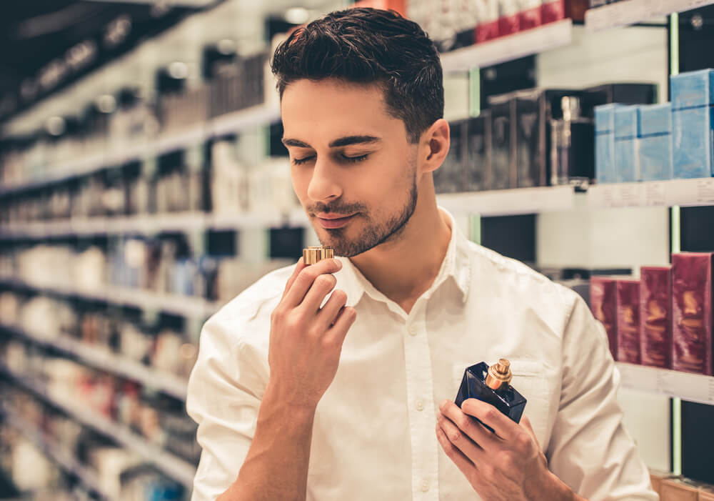 Man smelling fragrance in store
