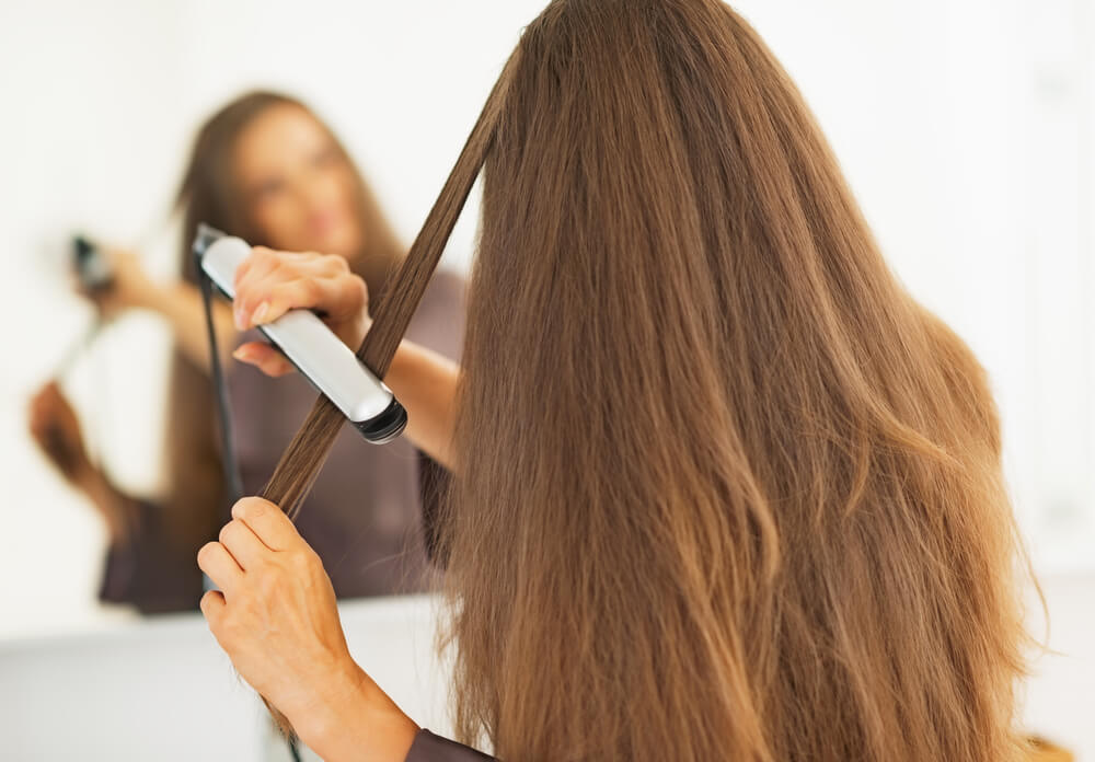 Woman straightening hair