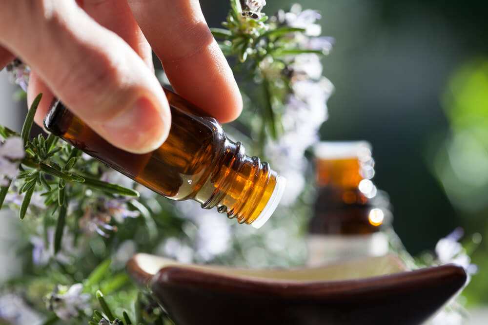 Hand pouring essential oil into bowl