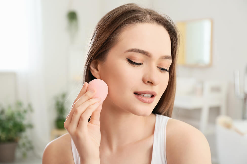 Woman using makeup sponge