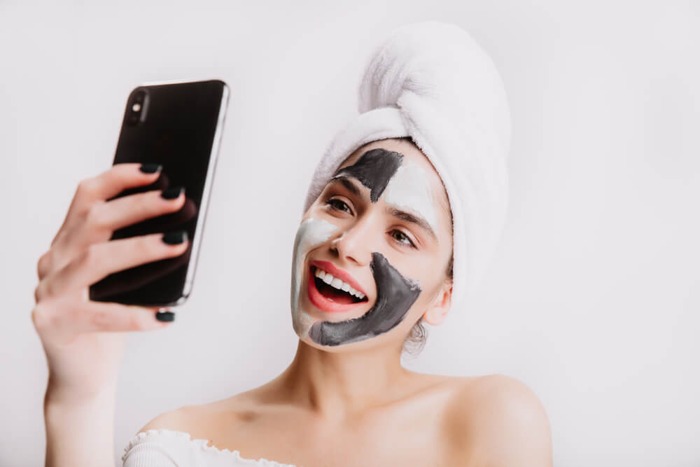 Woman taking face mask selfie